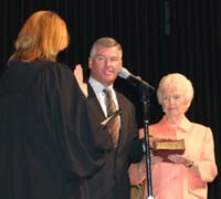Mayor Tim Davlin is sworn in on Friday, May 4, for a second term by Appellate Judge Sue Myerscough as his mother, Norene, holds a Bible.